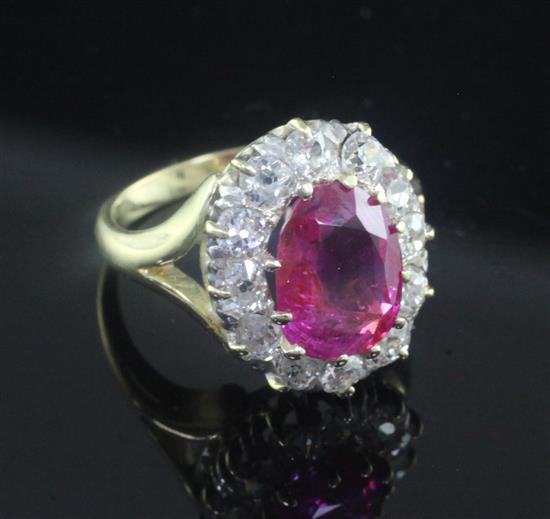 An 18ct gold, burmese ruby and diamond set oval cluster ring, size L.